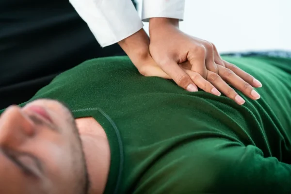 A healthcare professional performing a physical examination or palpation on a patient's abdomen to assess heart health.