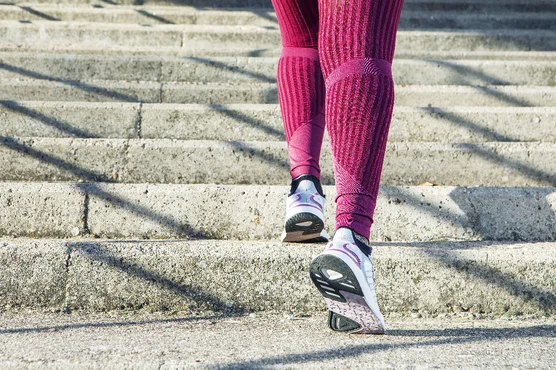 A jogger in red stockings runs up a set of steps