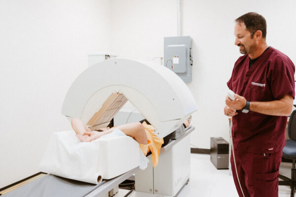 A CIS nurse operates a medical imaging machine to check for signs of vein disease