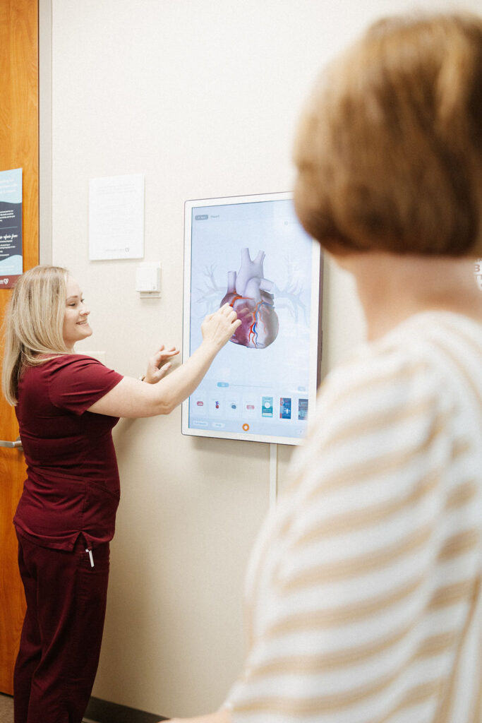 A nurse showing a diagram of a heart to a patient with mitral regurgitation
