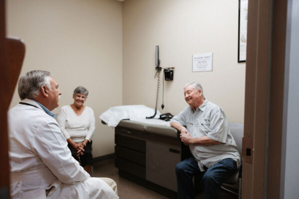 A CIS cardiologist consults with a patient and his wife in an exam room