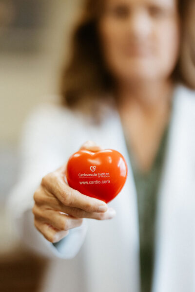 A CIS doctor holds a heart with the CIS logo on it