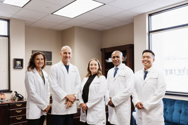 A group of CIS cardiology nurse practitioners in white coats poses for a photo