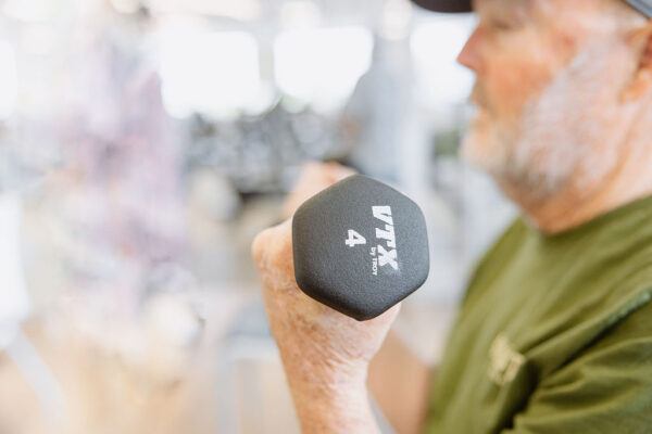 A cardiac rehab patient using a 4 pound hand weight during a workout