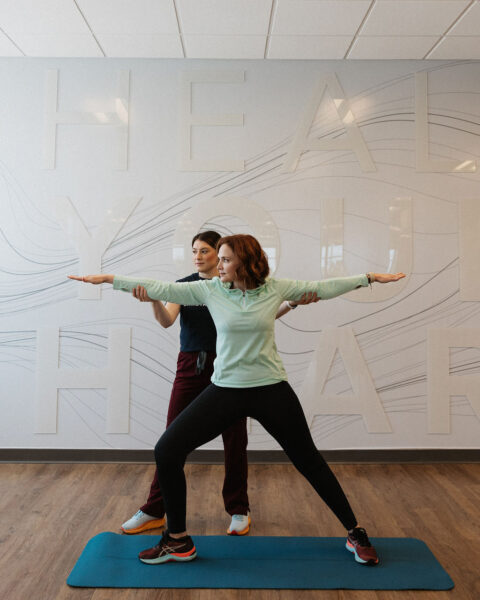 2 cardiac rehab therapists helping to demonstrate yoga poses