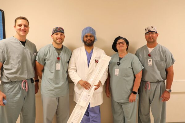 A group of happy looking CIS staff pose for a photo with the new Advisor™ HD Grid Mapping Catheter ™