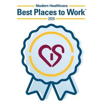 Award badge indicating "best places to work 2020" by modern healthcare, featuring a blue ribbon design with a heart and stethoscope symbol in the center, signifying a focus on cardiology