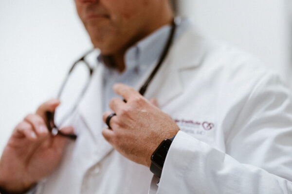 A blurred shot of a doctor putting on a stethoscope