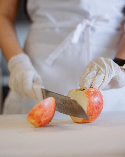 A cardiac rehab chef cutting a slice of an apple