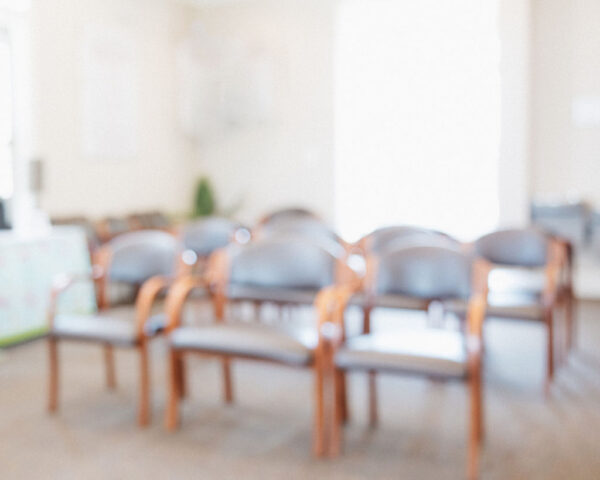 A blurry photo of rows of chairs in a waiting room at CIS