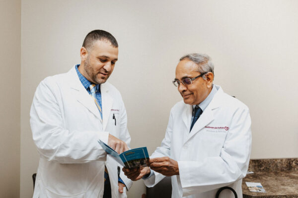 Sandeep Patel, MD, Interventional Cardiologist in Thibodaux, examines a pamphlet with another doctor