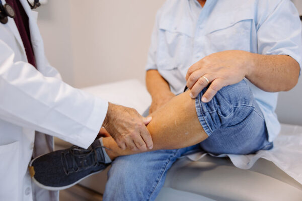 A doctor checks a patient's leg for signs of vein disease