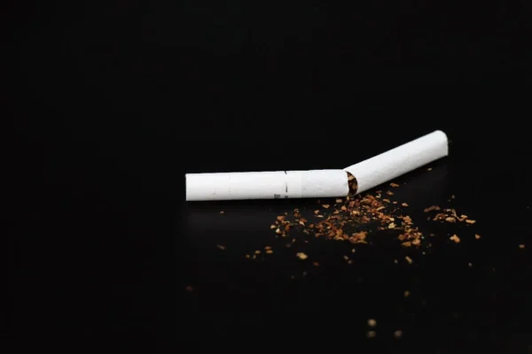 A broken cigarette on a black background with scattered tobacco symbolizes the work of the Cardiovascular Institute of the South in combating diseases caused by smoking.