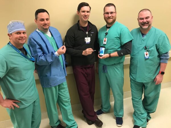 A group of CIS staff members pose with the Confirm Rx™ Insertable Cardiac Monitor