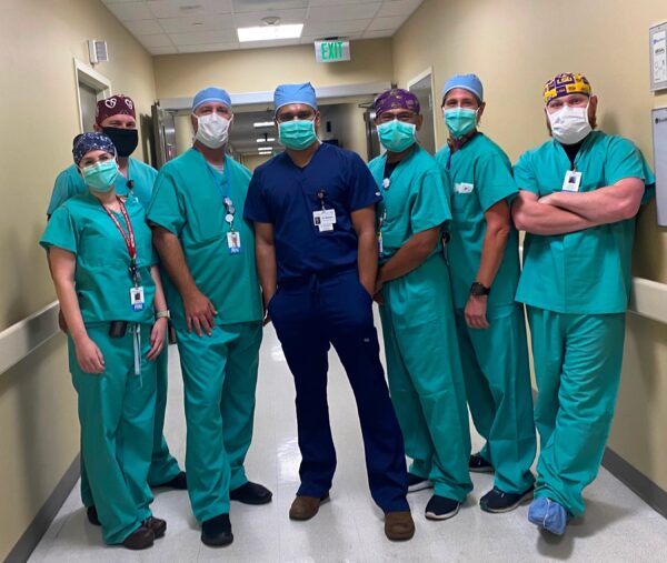 A group of CIS staff members in scrubs poses in a hospital hallway