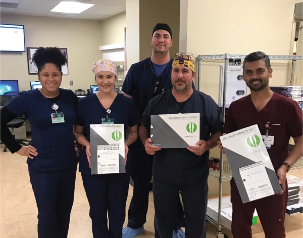 CIS staff members pose with boxes containing components for the Diamondback 360® Peripheral Orbital Atherectomy System