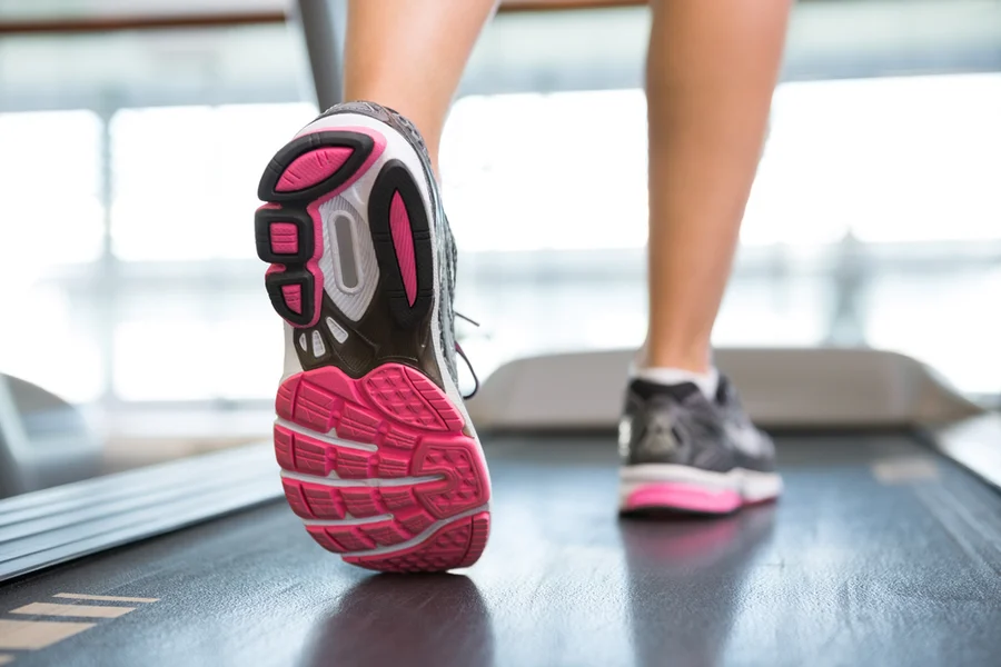 Close-up of a person's running shoes in motion on a treadmill at the Cardiovascular Institute of the South, highlighting an active lifestyle and fitness routine.