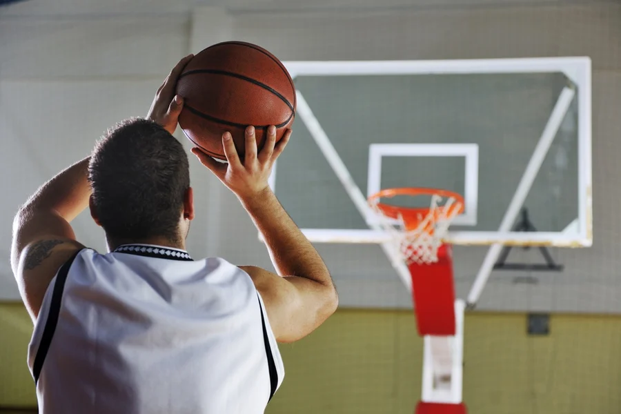 Taking aim: a basketball player focuses intently on the hoop as he prepares to shoot, embodying concentration and determination in the game, akin to a cardiologist at the Cardiovascular Institute of the South