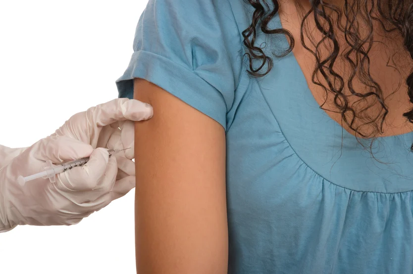 Healthcare in action: a patient receives a vaccination in the upper arm, a common practice to maintain public health and prevent venous disease.
