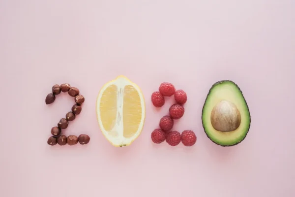 Healthy foods forming "2020" on a pink background, recommended by cardiologists.