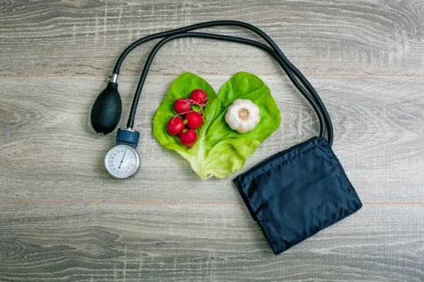 Blood pressure cuff and healthy food representing a heart health-conscious lifestyle.