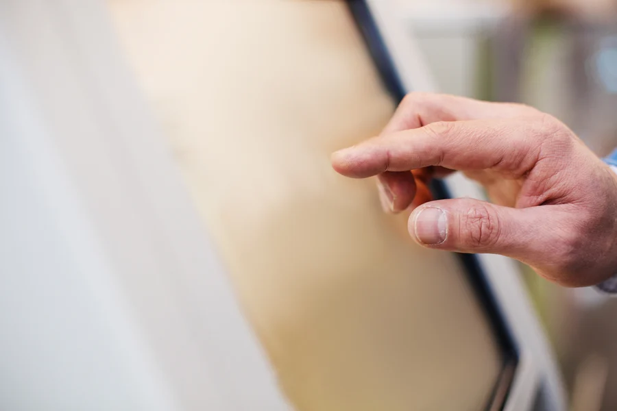 A person's hand gently touching a smooth surface of a digital device, possibly interacting with an application related to heart health designed by the Cardiovascular Institute of the South.