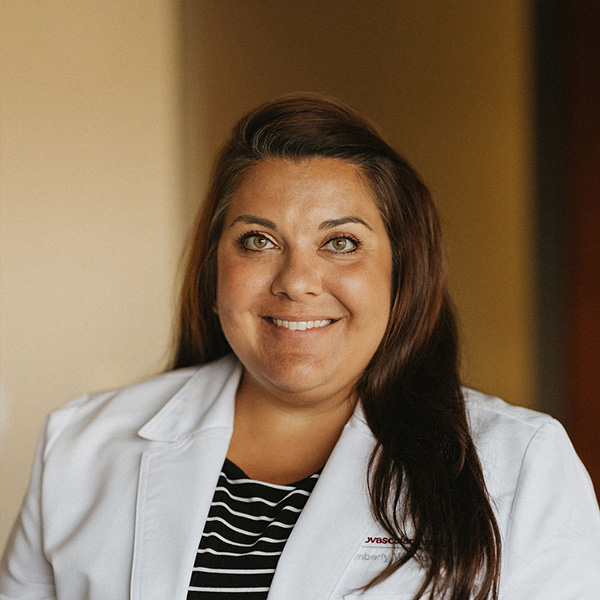 A confident healthcare professional in a white coat, sporting a friendly smile.