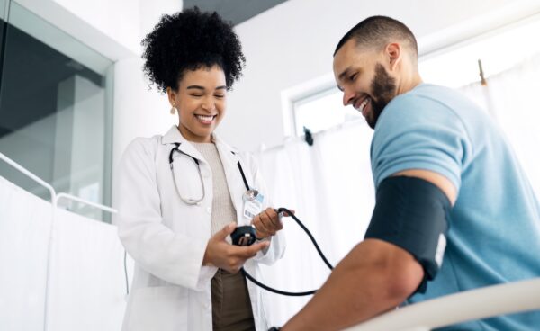 Happy doctor with patient, checking blood pressure